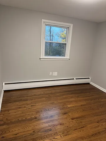 a view of a room with wooden floor and window