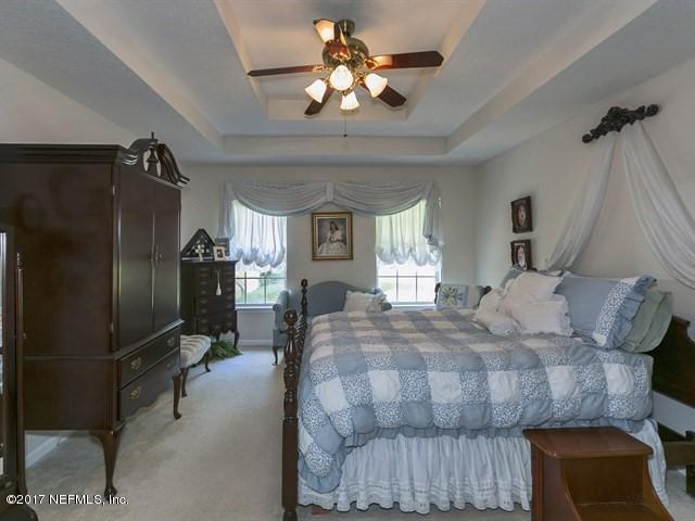 1204 Ribbon Road St. Johns, FL 32259 - Photo 9 of 26 a bedroom with a bed and a chandelier