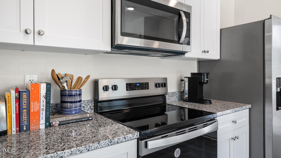 8514 Beckett Chase Way Raleigh, NC 27616 - Photo 7 of 29 a kitchen with stainless steel appliances granite countertop a stove and a microwave