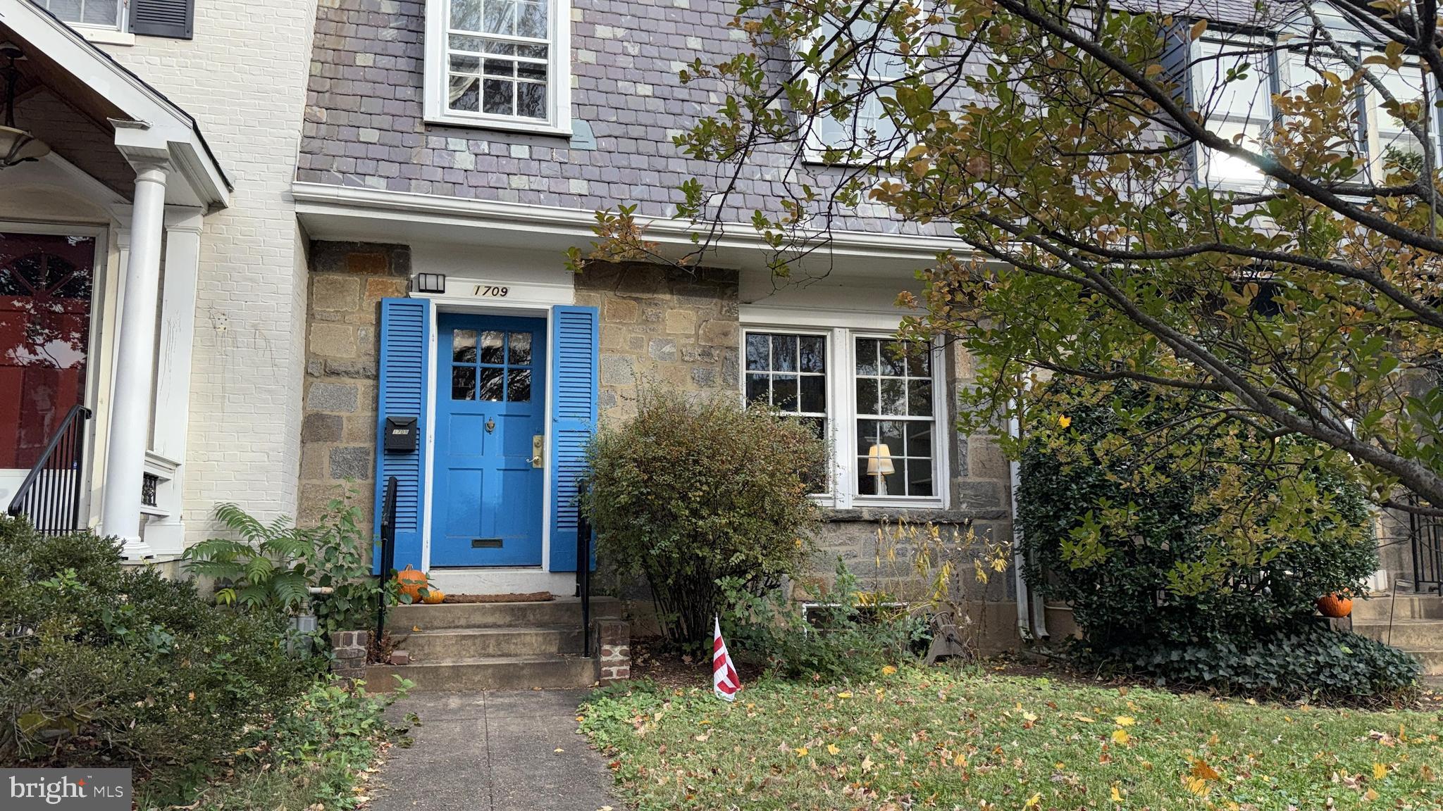 a view of a house with brick walls and a tree