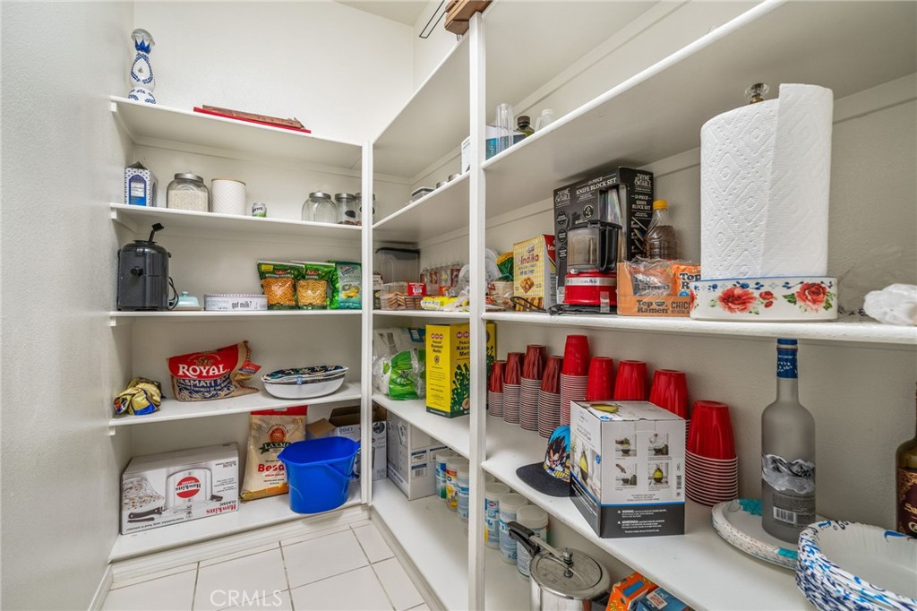 13243 Stanton Drive Rancho Cucamonga, CA 91739 - Photo 19 of 53 a storage room with stainless steel appliances kitchen island lots of clutter