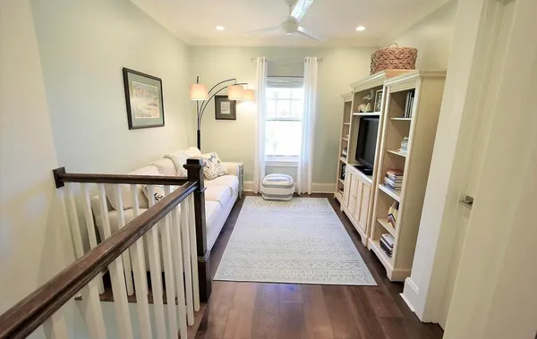 a view of a hallway with wooden floor and stairs
