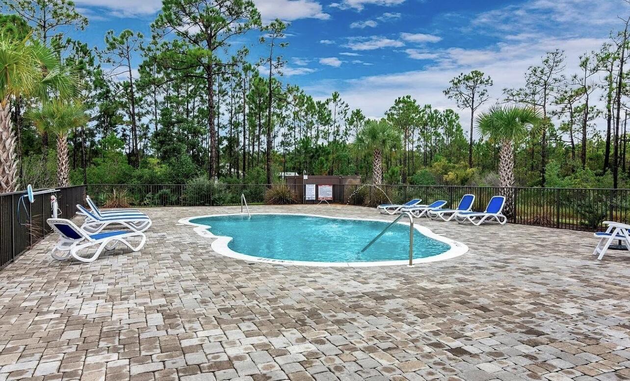 92 Heron's Crossing Santa Rosa Beach, FL 32459 - Photo 27 of 28 a view of a swimming pool with a sitting space