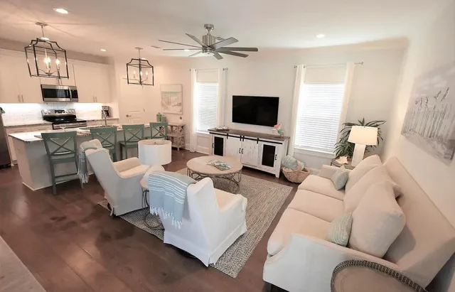 a living room with furniture a flat screen tv and kitchen view