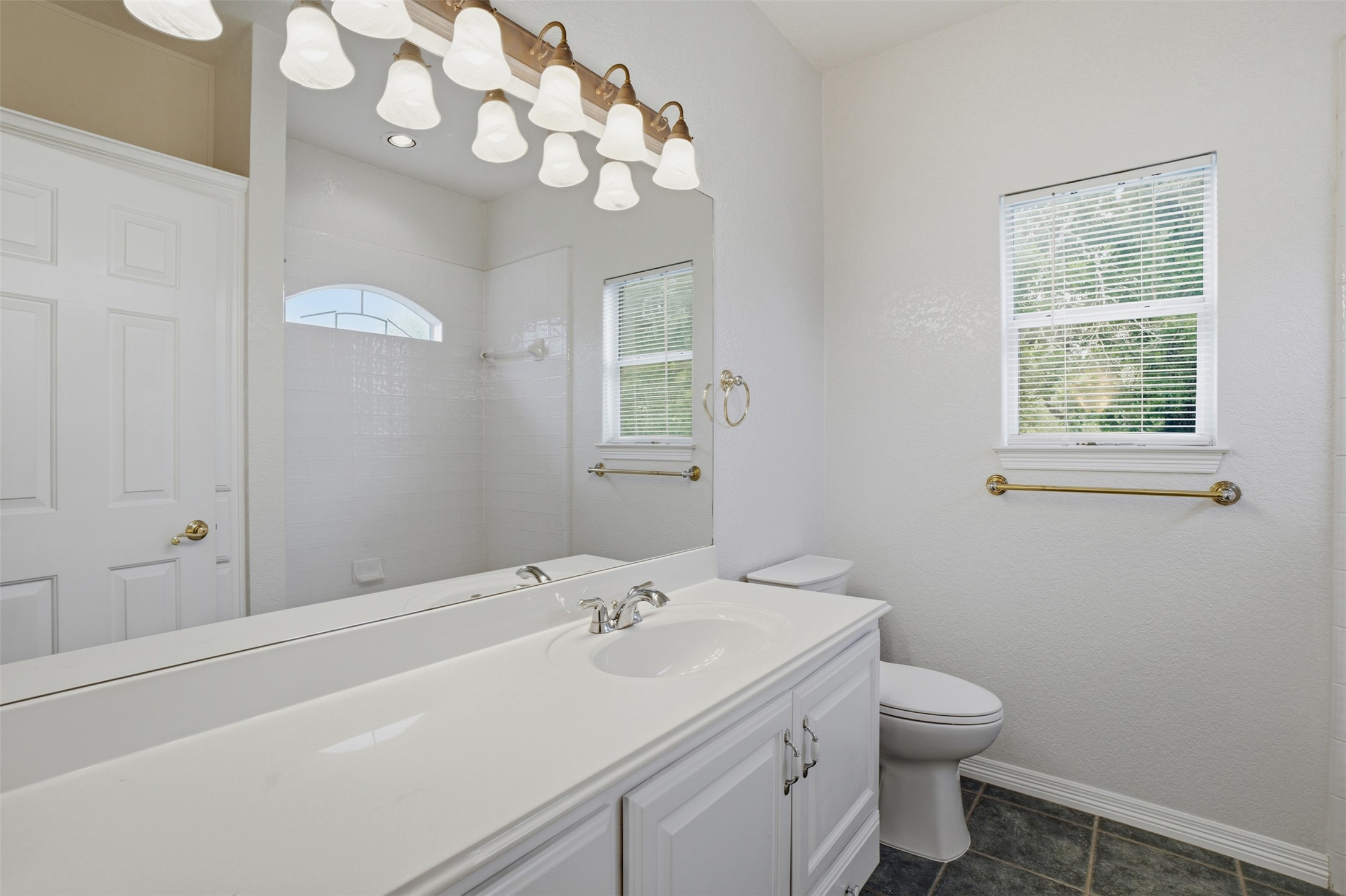 1301 County Road 262 Georgetown, TX 78633 - Photo 24 of 39 White vanity with an integrated sink, polished chrome faucet, and expansive wall-mounted mirror