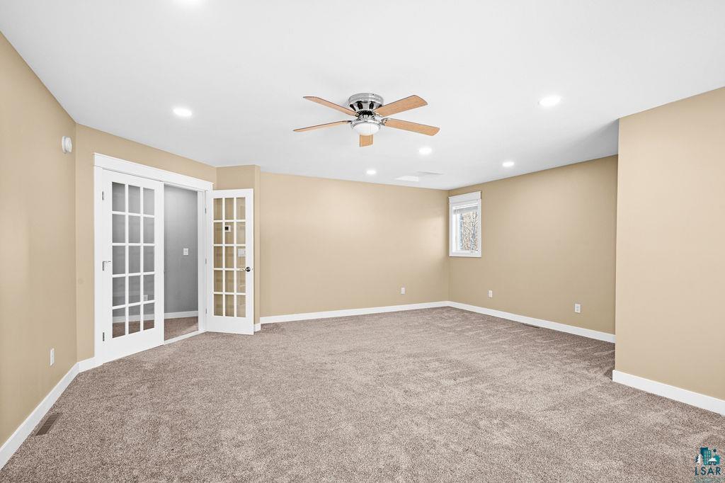 3879 Okerstrom Road Hermantown, MN 55811 - Photo 23 of 32 Spare room with french doors, ceiling fan, light colored carpet, and recessed lighting