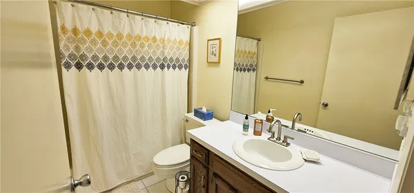 a bathroom with a sink a toilet and shower curtain