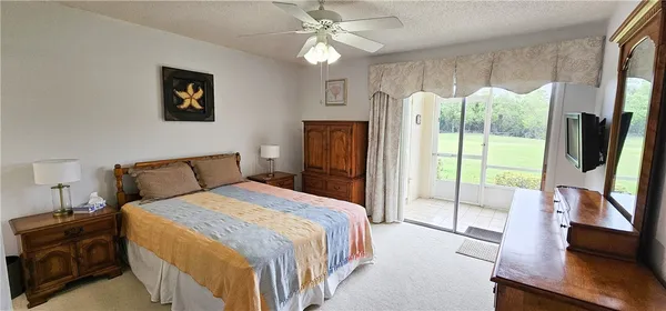 a bedroom with a bed flat screen tv and a large window