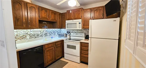 a kitchen with stainless steel appliances granite countertop a refrigerator a stove a sink and a microwave