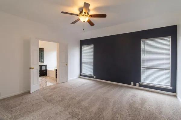 an empty room with a ceiling fan and a window