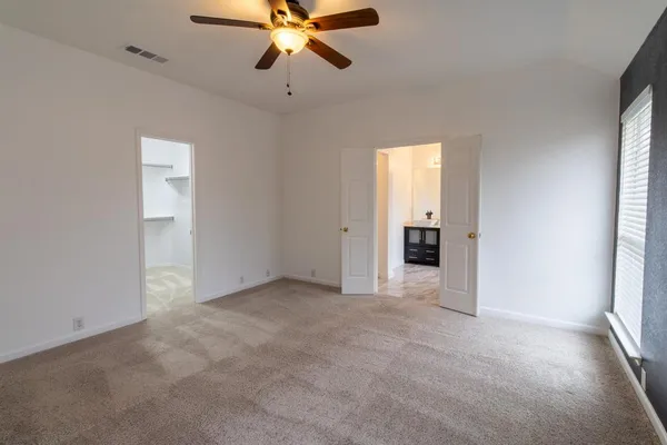 an empty room with a ceiling fan and a window