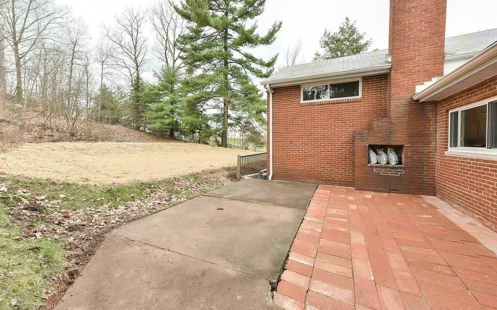 1463 Anderson Road Pittsburgh, PA 15209 - Photo 11 of 22 Outdoor fireplace, new patio, new grass seed, new railing, cement wall and steps to Walk Out Basement door.
