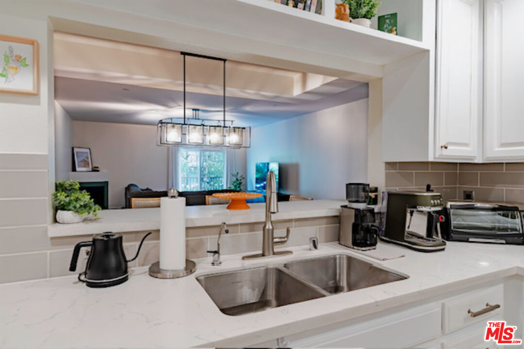 956 South Wilton Place, Unit 305 Los Angeles, CA 90019 - Photo 16 of 18 a kitchen that has a lot of cabinets a sink and a stove in it