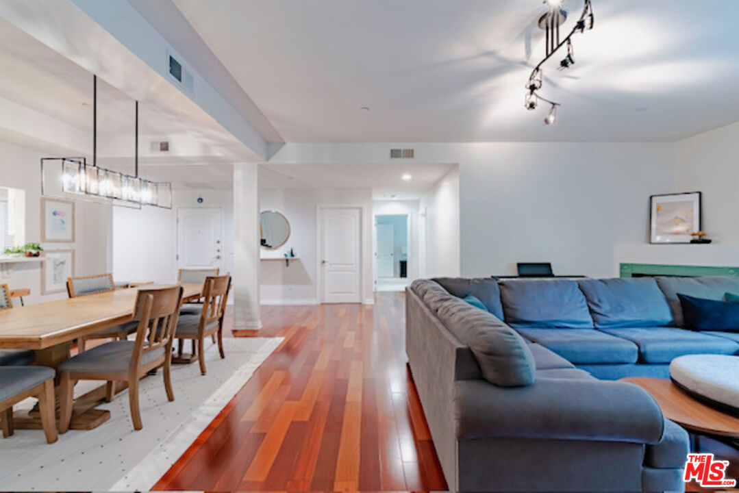 956 South Wilton Place, Unit 305 Los Angeles, CA 90019 - Photo 5 of 18 a living room with furniture a dining table and a chandelier