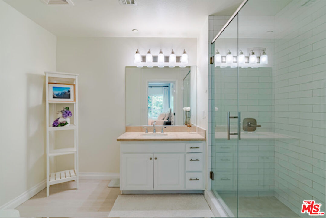 956 South Wilton Place, Unit 305 Los Angeles, CA 90019 - Photo 7 of 18 a bathroom with a sink shower and a mirror