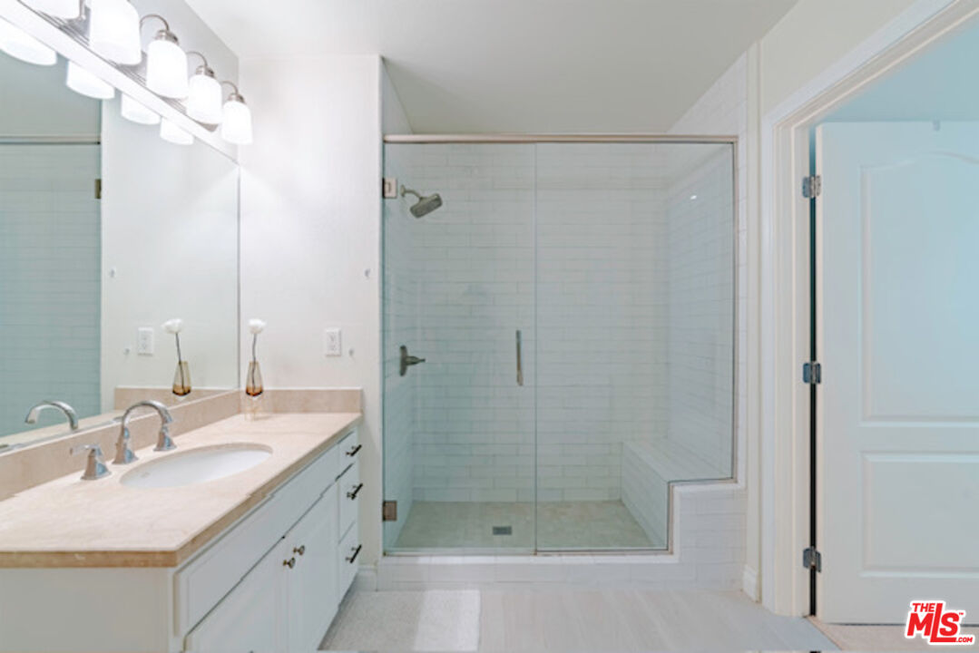 956 South Wilton Place, Unit 305 Los Angeles, CA 90019 - Photo 8 of 18 a bathroom with a shower sink vanity granite and shower