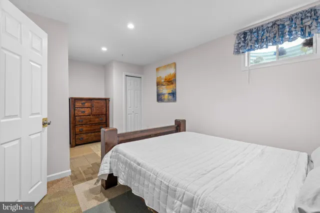 a bedroom with a bed and a painting on the wall