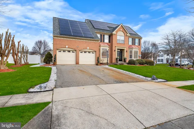 a front view of a house with a yard and potted plants