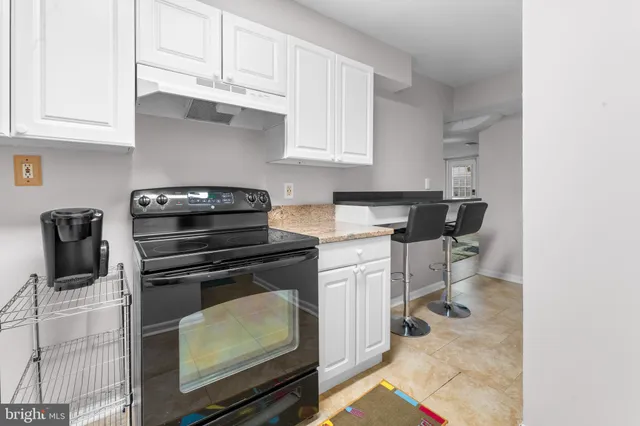 a kitchen with white cabinets and appliances
