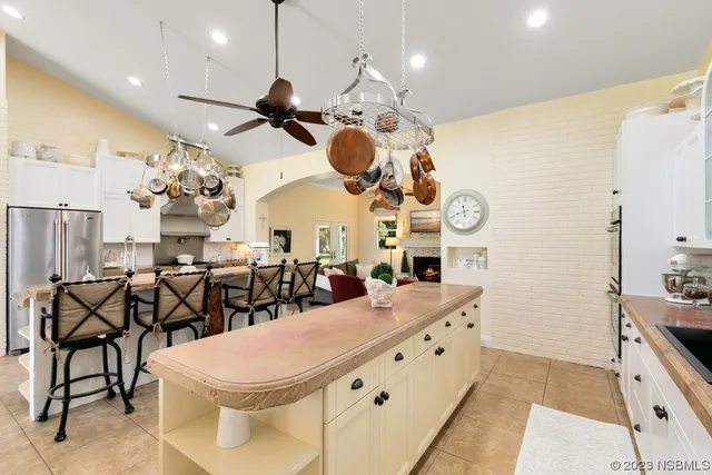 a kitchen with stainless steel appliances kitchen island granite countertop a stove a sink and a refrigerator