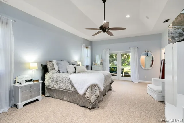 a spacious bedroom with a bed mirror and window