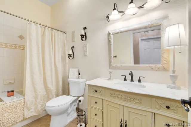 a bathroom with a sink a toilet a mirror a vanity and shower