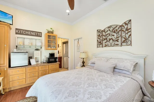 a bedroom with a large bed and a flat tv screen on dresser