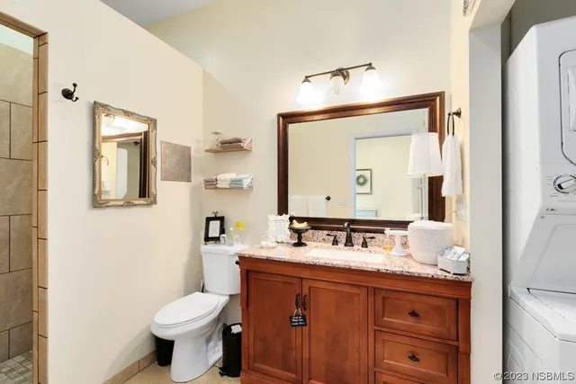 a bathroom with a granite countertop sink toilet and mirror