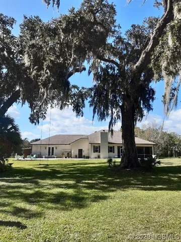 a view of a house with backyard porch and sitting area