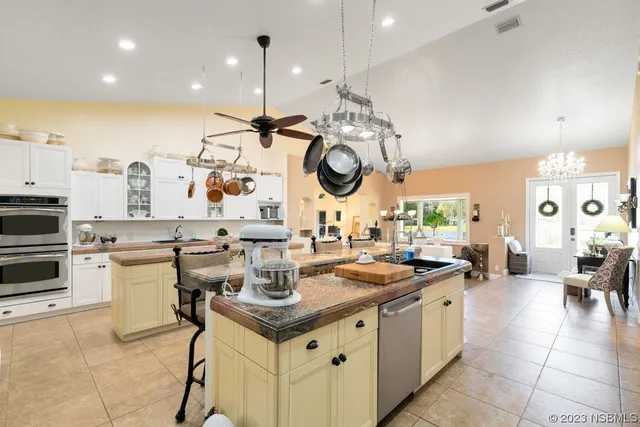 a kitchen with a sink a stove cabinets and living room view
