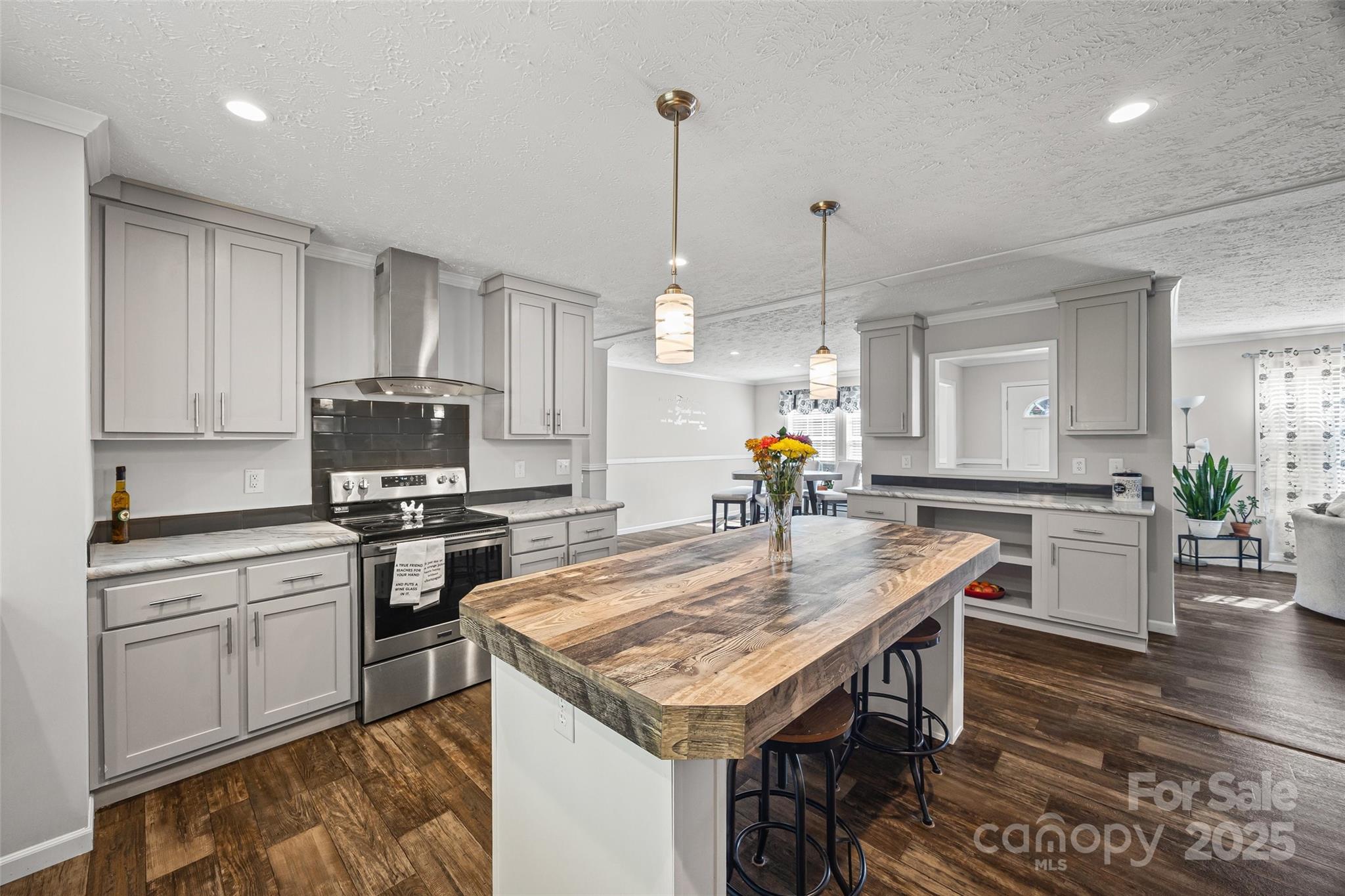 1804 Tom Joye Road Clover, SC 29710 - Photo 10 of 28 a kitchen with stainless steel appliances granite countertop a kitchen island hardwood floor sink stove dining table and chairs