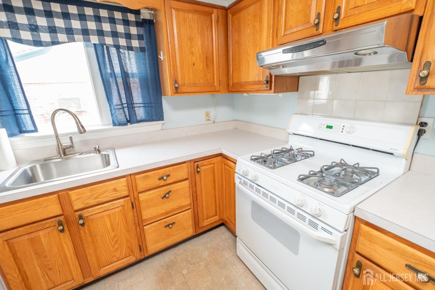 203 New Market Road Dunellen, NJ 08812 - Photo 14 of 44 a kitchen with stainless steel appliances granite countertop a sink stove and refrigerator