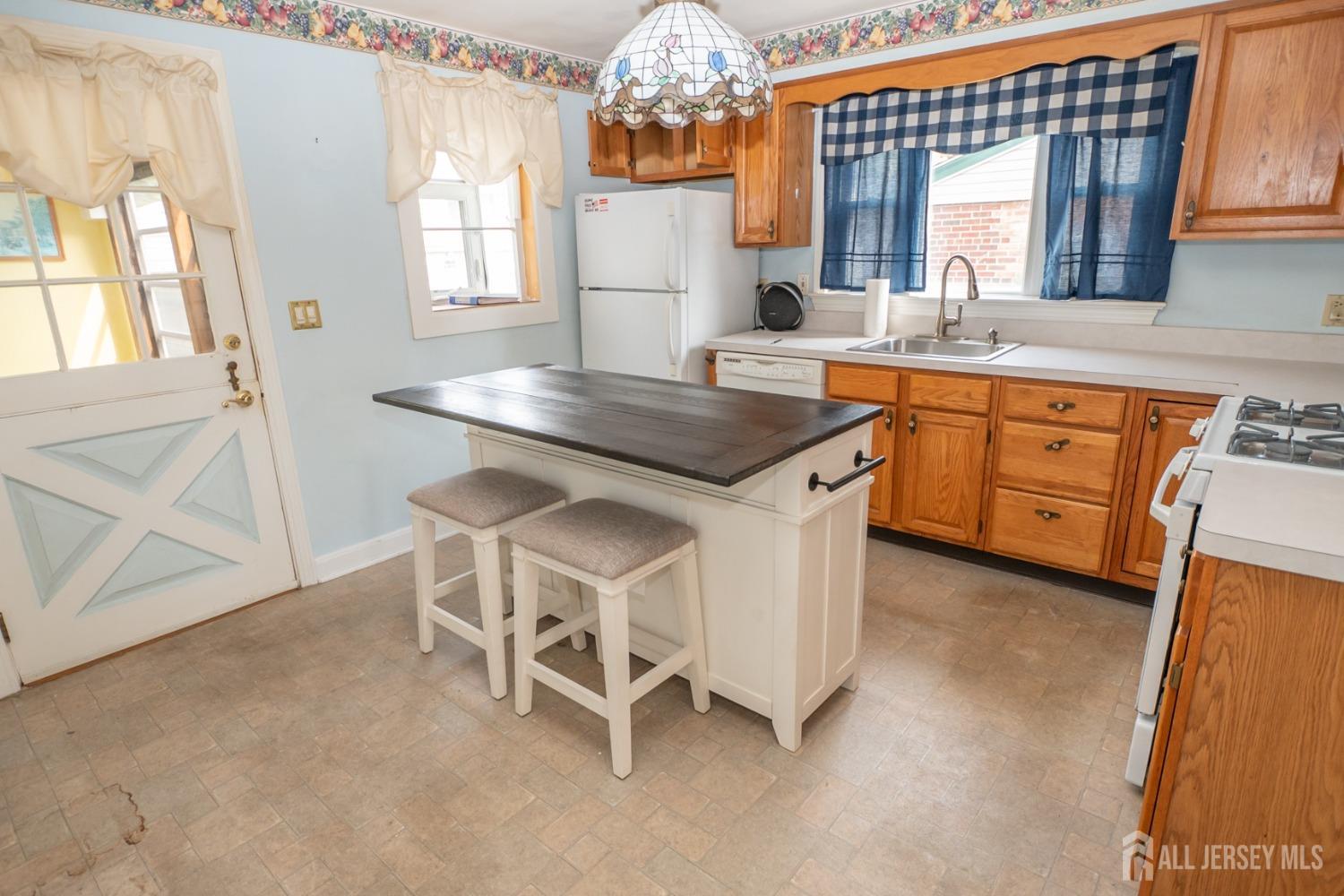 203 New Market Road Dunellen, NJ 08812 - Photo 9 of 44 a kitchen with cabinets a sink dining table and chairs
