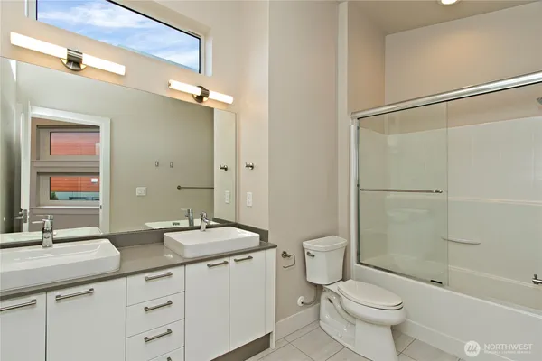 a bathroom with a granite countertop sink mirror toilet and bathtub
