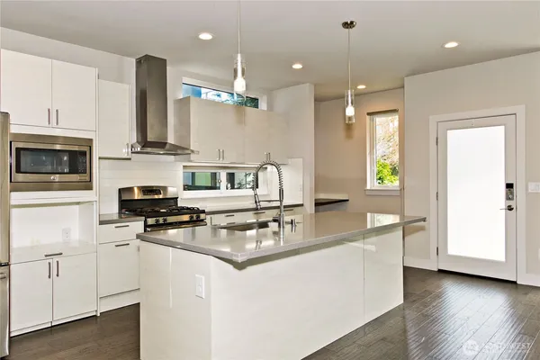 a kitchen with stainless steel appliances granite countertop a sink a stove and a refrigerator