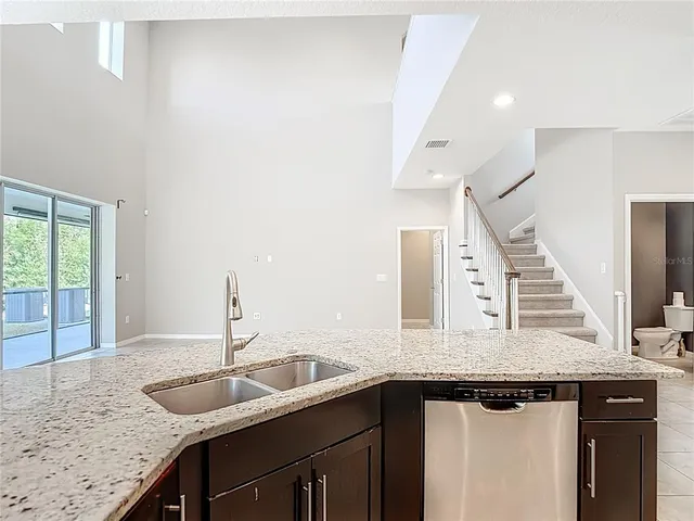 an empty room with wooden floor chandelier fan and windows