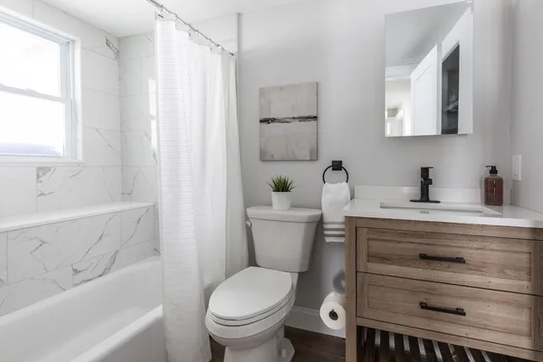 a bathroom with a sink a toilet and shower