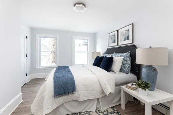 a spacious bedroom with a bed and chair