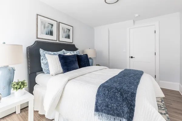 a bedroom with a bed and a painting on the wall