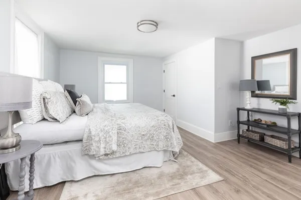 a bedroom with a bed and wooden floor