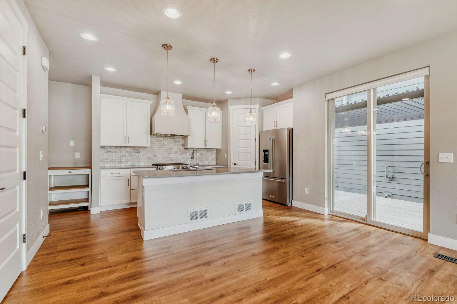 6850 Decatur Street Denver, CO 80221 - Photo 12 of 30 a large kitchen with kitchen island a sink stainless steel appliances and cabinets