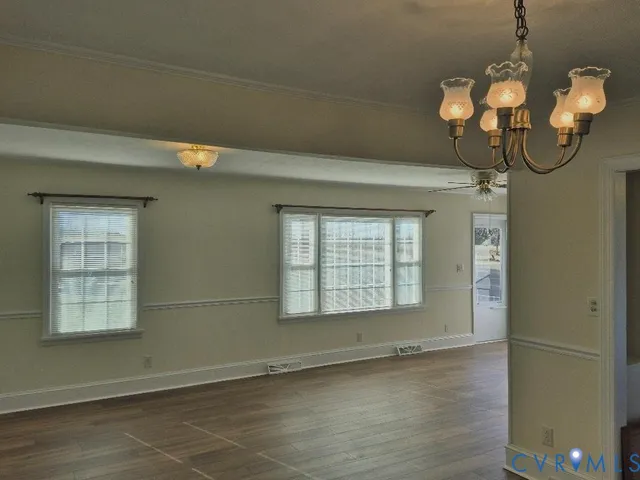 a view of a room with wooden floor and chandelier