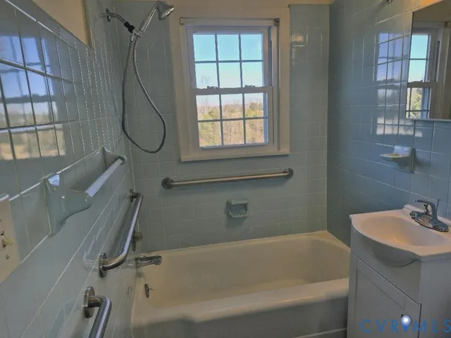 a bathroom with a bathtub a window and a shower