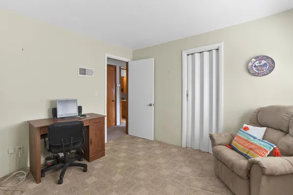 a view of a workspace with furniture and a window