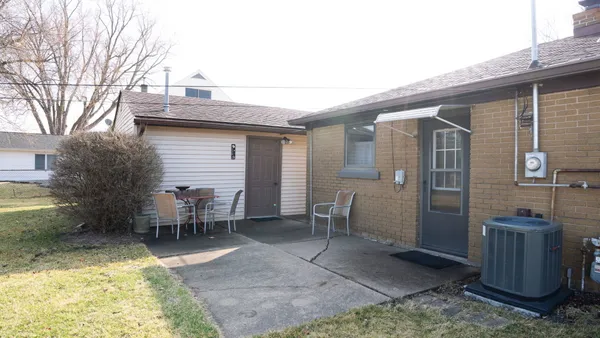 a view of a patio with table and chairs and wooden fence
