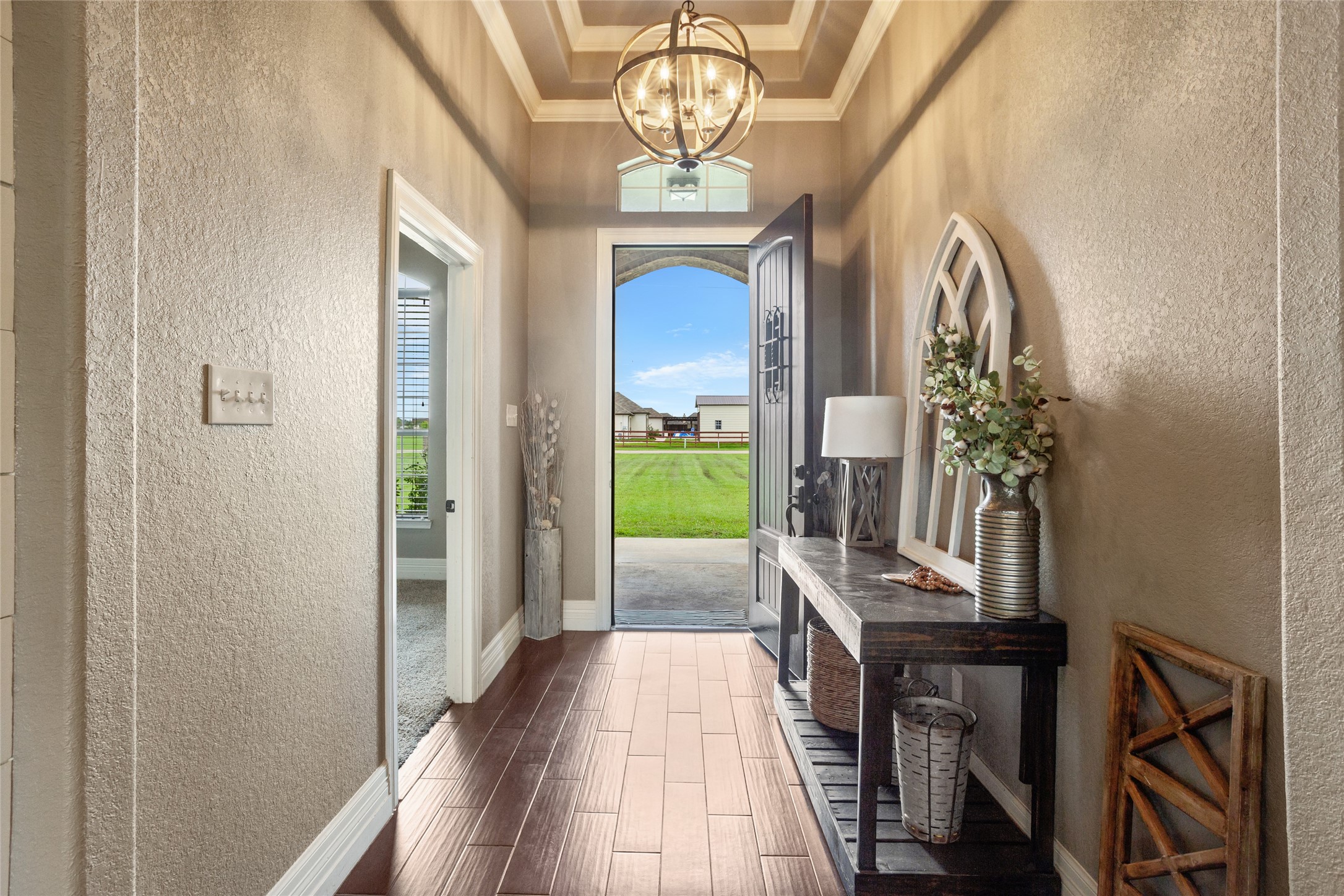 7842 Pebble Hill Lane Rosharon, TX 77583 - Photo 8 of 33 a view of a hallway with wooden floor and a chandelier