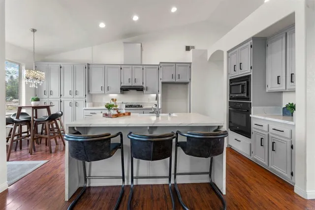 a kitchen with a wooden floor and a view of dining hall with wooden floor