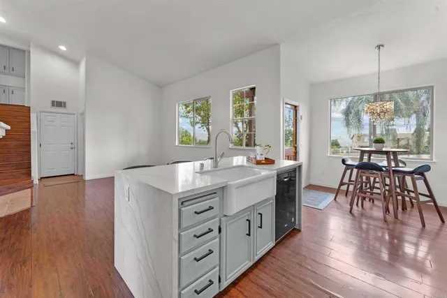 a kitchen that has a sink a stove and cabinets