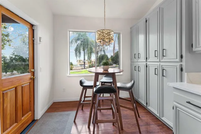 a view of a hallway with wooden floor and a bathroom