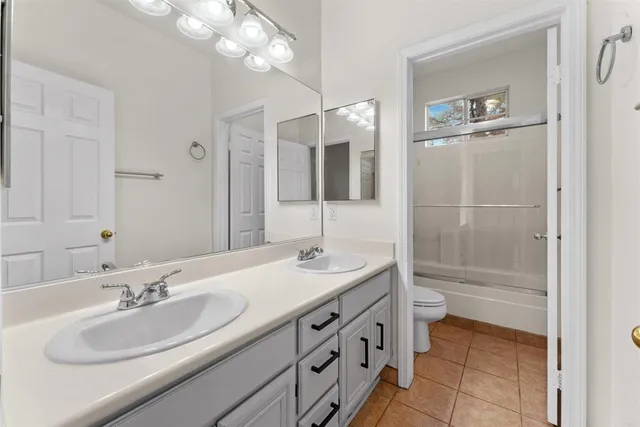 a bathroom with a granite countertop bathtub shower and toilet